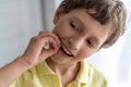 A brave little boy of 7 years old shakes his baby tooth