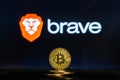 Brave logo on a computer screen with a stack of Bitcoin cryptocurency coins. Royalty Free Stock Photo