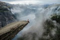 Brave man sitting on the edge Trolltunga. Norway Royalty Free Stock Photo