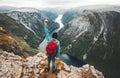 Brave Man traveling in Norway mountains standing on cliff