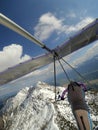 Brave pilot fly over mountain peak cobered by snow on a hang glider