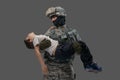 Brave soldier patriot carrying injured kid against grey background