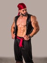 A Brave Soul in Crimson: A Male Bodybuilder with a Red Bandanna Standing Proudly Before a Clean Canvas