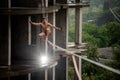 Brave topless man balancing on a slackline on rainy day