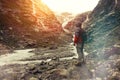 Brave traveler with a backpack looking at a glacier and is preparing for the ascent