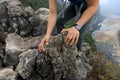 Backpacker climbing rock on mountain top cliff edge Royalty Free Stock Photo