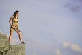 Brave woman stand alone in high mountains blue sky background. Depression concept. Soldier girl. Military female