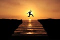 Brave Young Man jumping over the cliff, silhouette Sunset background. Business Goal Achieve concept Royalty Free Stock Photo