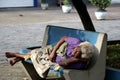 Brazil - elderly woman waking up after sleeping on the bank of the square