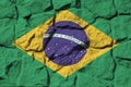 Brazil flag depicted in paint colors on old stone wall closeup. Textured banner on rock wall background