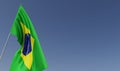 Brazil flag on flagpole on blue background. Place for text. The flag is flutters in wind. South America. Brazilian. 3D