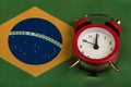 Brazil flag and vintage alarm clock close up. Time to travel to Brazil Royalty Free Stock Photo