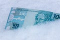 Brazil money, 100 reais banknote lying in the snow, financial concept, spending freeze