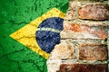 Brazil national flag painted cracked divided peeling pain brick wall cement facade background. Political economical crisis concept Royalty Free Stock Photo