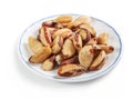 Brazil nuts peeled on a white saucer with a blue border, isolated on a white background
