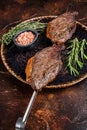 Brazilian BBQ - grilled dry aged picanha beef steak with herbs. Dark background. Top view Royalty Free Stock Photo