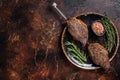 Brazilian BBQ - grilled dry aged picanha beef steak with herbs. Dark background. Top view. Copy space Royalty Free Stock Photo