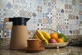 Brazilian breakfast. Breakfast table with coffee thermos, cup and fruits in the basket