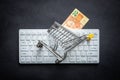 Brazilian cash, White computer keyboard, Miniature shopping cart, Black background, Online shopping concept in stores, Low prices Royalty Free Stock Photo