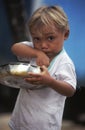 Brazilian child eating from saucepan.