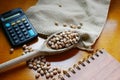 Brazilian commodities. Carioca beans in a wooden spoon, calculator and notebook