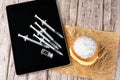 Brazilian cream donuts next by several syringes and ampoules with insulin on the tablet_top view