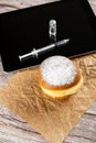 Brazilian cream doughnuts next to a syringe and an ampoule of insulin on a tablet_vertical