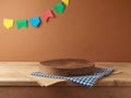 Brazilian Festa Junina summer harvest festival concept. Empty wooden podium with tablecloth on table over wall background. Mock