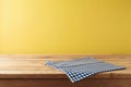 Brazilian Festa Junina summer harvest festival concept. Empty wooden table with tablecloth over yellow background. Mock up for