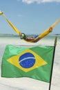 Brazilian Flag Waving in front of Beach Hammocks Royalty Free Stock Photo