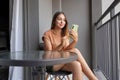 Brazilian girl using smartphone for chat or checking messages relaxed on her balcony at home Royalty Free Stock Photo