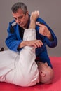 Brazilian jiu jitsu instructor demonstrates ground fighting arm Royalty Free Stock Photo