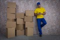 Brazilian mailman using a smartphone in front of a lot of packages