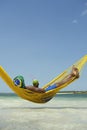 Brazilian Man Relaxing in Beach Hammock with Drinking Coconut Royalty Free Stock Photo