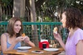 Brazilian girl friends eating pao de queijo and coxinha food snack outdoors in Sao Paulo during summer. Royalty Free Stock Photo