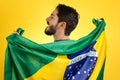 Brazilian soccer football player holding Brazil flag.