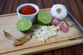 Brazilian spices. Spices in a cutting board, lemon, sliced garlic and garlic bulb, bay leaves and paprika powder Royalty Free Stock Photo