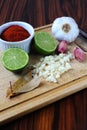 Brazilian spices. Seasonings on the cutting board. Lemon, sliced garlic, paprika powder and bay leaves Royalty Free Stock Photo
