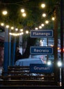 Brazilian street pole signs with location names with lights in the background, Rio de Janeiro