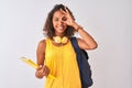 Brazilian student woman wearing backpack holding notebook over isolated white background with happy face smiling doing ok sign Royalty Free Stock Photo