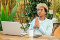 Brazilian woman at blue t-shirt and glasses eyewear closed eyes and having calm breathe at tropical summer bali cafe.she