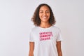 Brazilian woman wearing fanny t-shirt with irony comments over isolated white background with a happy face standing and smiling