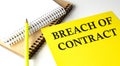 BREACH OF CONTRACT text written on a yellow paper with notebook Royalty Free Stock Photo