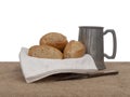 Bread and ale, rustic lunch, with old pewter tankard, bread rolls and knife. Still life.