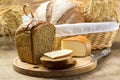 Bread and cheese sliced for sandwiches amid the loaves in a wicker basket with ears of wheat Royalty Free Stock Photo