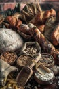 Bread background. Brown and white whole grain loaves wrapped in kraft paper composition on rustic dark wood with wheat ears scatte Royalty Free Stock Photo