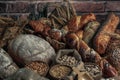 Bread background. Brown and white whole grain loaves wrapped in kraft paper composition on rustic dark wood with wheat ears scatte Royalty Free Stock Photo