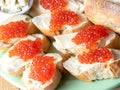 Bread and butter sandwiches with red caviar on a plate.