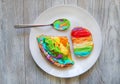 The bread, cake and spoon is colorful cream. Rainbow on bread. Breakfast
