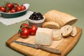 Bread and cheese/Delicious organic cream milk cheese, olives and home-made bread and ripe tomatoes on wooden board. Royalty Free Stock Photo